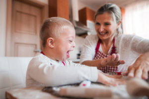 laughing child with his mother indoors baking