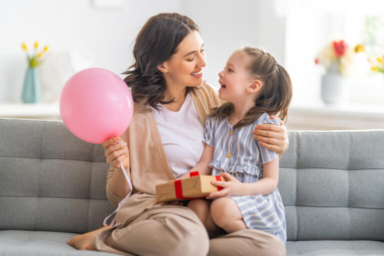 Mother and daughter smiling and holding gift