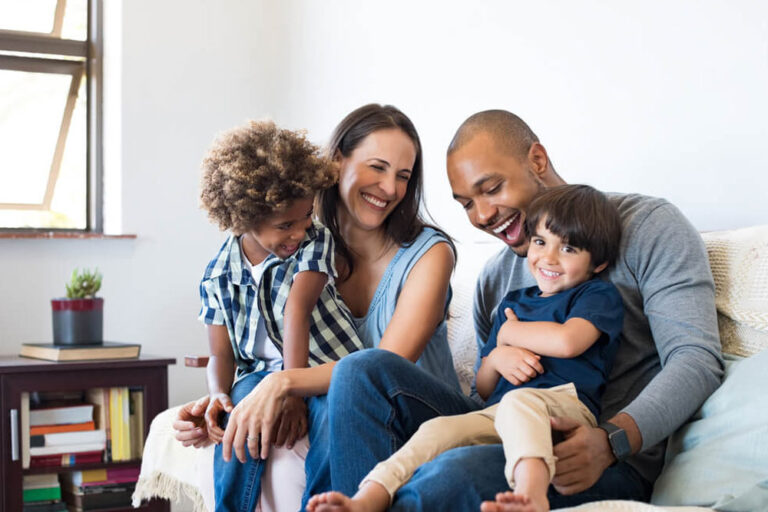 Happy family sitting on sofa laughing together